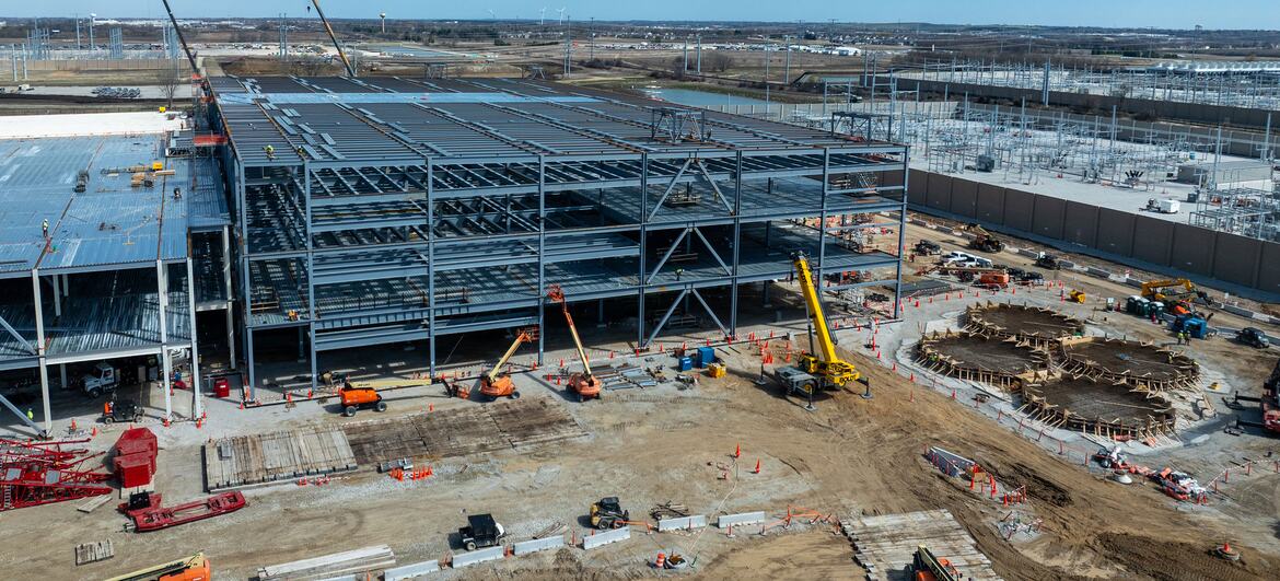 Vue aérienne d'un centre de données Microsoft en construction à Mount Pleasant, dans le Wisconsin, montrant une structure en acier et des engins lourds sur le site.