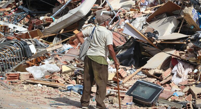 Un anciano con bastón permanece de pie entre los escombros de un edificio derrumbado en La Guaira, Venezuela, tras los devastadores terremotos de junio de 2026.