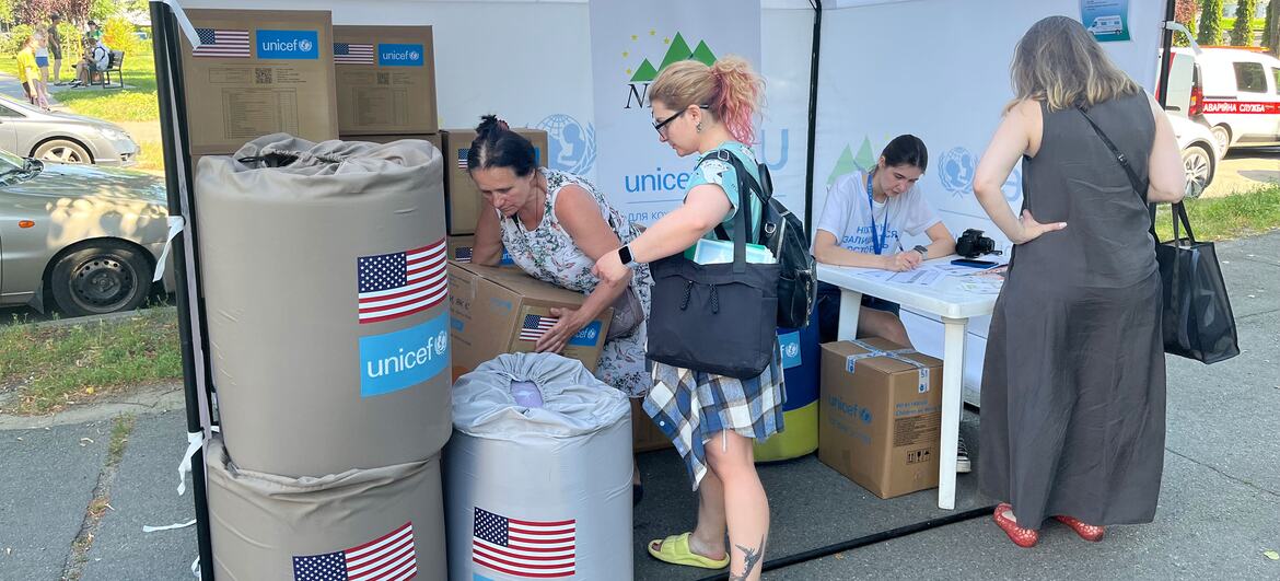 Волонтеры раздают гуманитарную помощь UNICEF из палатки в Украине.