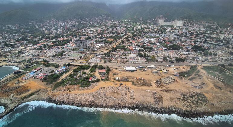 Vista aérea de la ciudad costera de La Guaira, Venezuela, que muestra los extensos escombros del terremoto y una zona de reconstrucción.