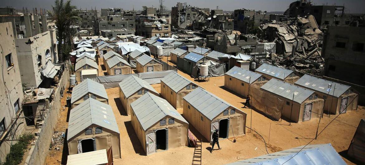 Aerial view of a UNDP refugee camp in Gaza with temporary shelters and damaged buildings.