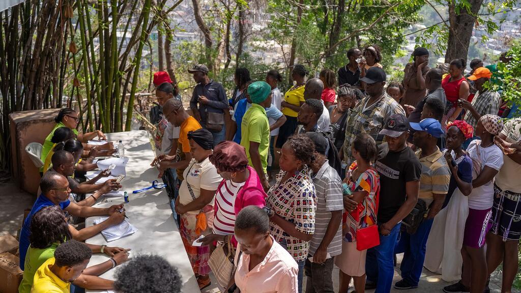 En Haïti, une file de personnes attend de recevoir une aide financière du PAM dans un centre d