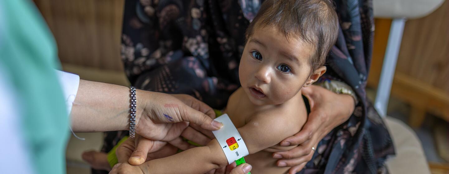 Muuguzi wa lishe hupima mzingo wa katikati ya mkono wa juu (MUAC) wa mtoto wa miezi 8 anayeitwa Satayesh katika kliniki ya afya huko Herat, Afghanistan.