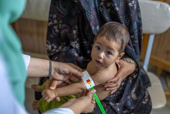 A nutrition nurse measures the mid-upper arm circumference (MUAC) of an 8-month-old baby named Satayesh at a health clinic in Herat, Afghanistan.