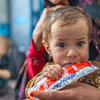 A young child, Zainab, eats Ready-to-Use Therapeutic Food (RUTF) during a follow-up visit at a clinic in Afghanistan.