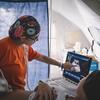 A medical professional performs an ultrasound on a patient inside a temporary tent structure.