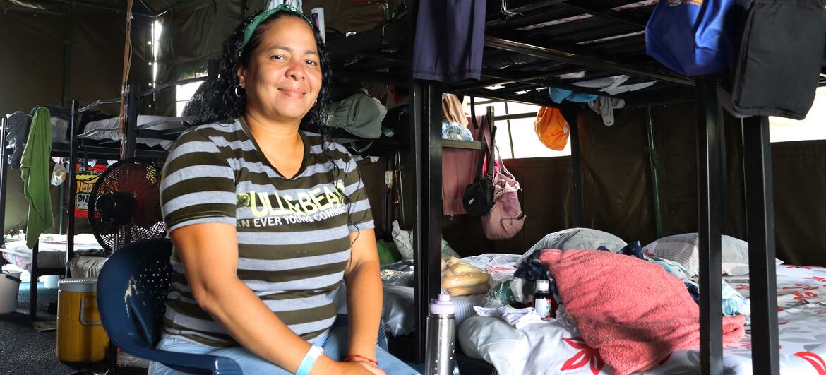 Yoseys Escalona sits in a blue chair inside a temporary tent at a displacement camp in Venezuela.