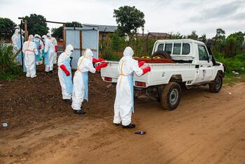 Members of a Safe and Dignified Burial team in protective gear prepare to load a body into a truck at an Ebola Treatment Centre in Rwampara, Ituri Province, Democratic Republic of the Congo.
