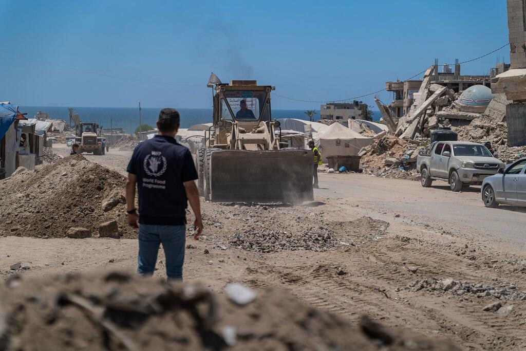 Mfanyakazi wa Mpango wa Chakula Duniani akisimamia tingatinga linaposaga vifusi ili kutengeneza barabara huko Gaza.