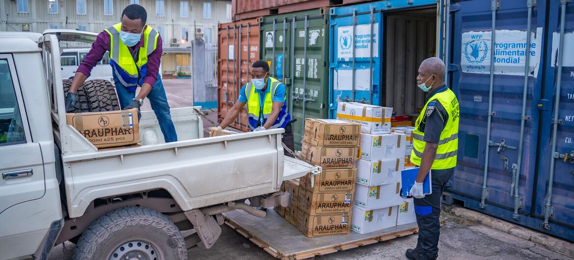 En el aeropuerto de N'djili, en Kinshasa, República Democrática del Congo, equipos del PMA , con chalecos y máscaras de seguridad, cargan cajas de mercancías en un camión para una misión de respuesta al ébola.