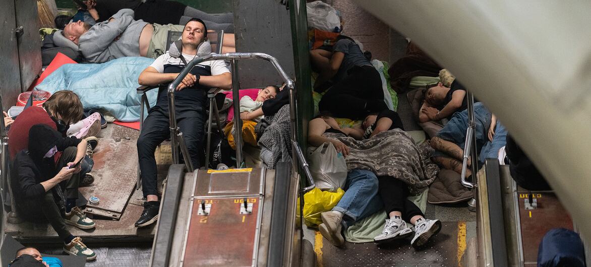 Families and children sleep on the floor and escalators inside a crowded Kyiv metro station for shelter from air raids in Ukraine.