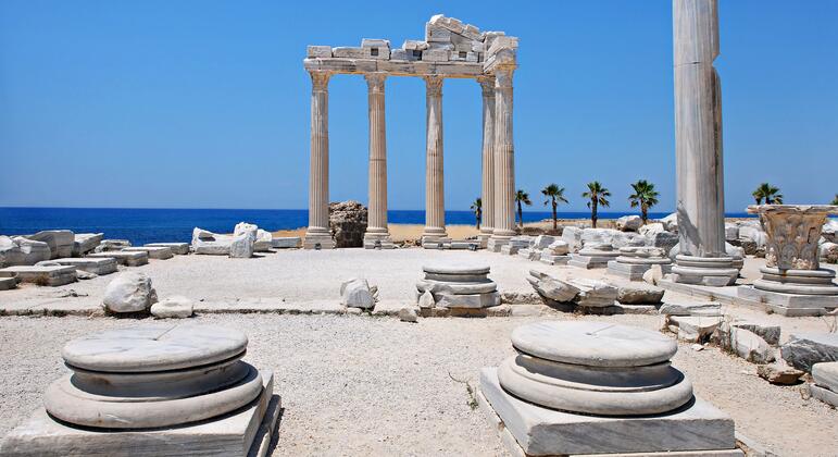 The Temple of Apollo in Side, Türkiye, with its restored Corinthian columns and stone ruins overlooking the Mediterranean Sea under a clear blue sky.
