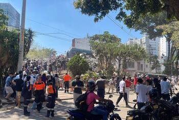 Emergency responders and crowds gather at a collapsed building site in Cali, Colombia following an earthquake.