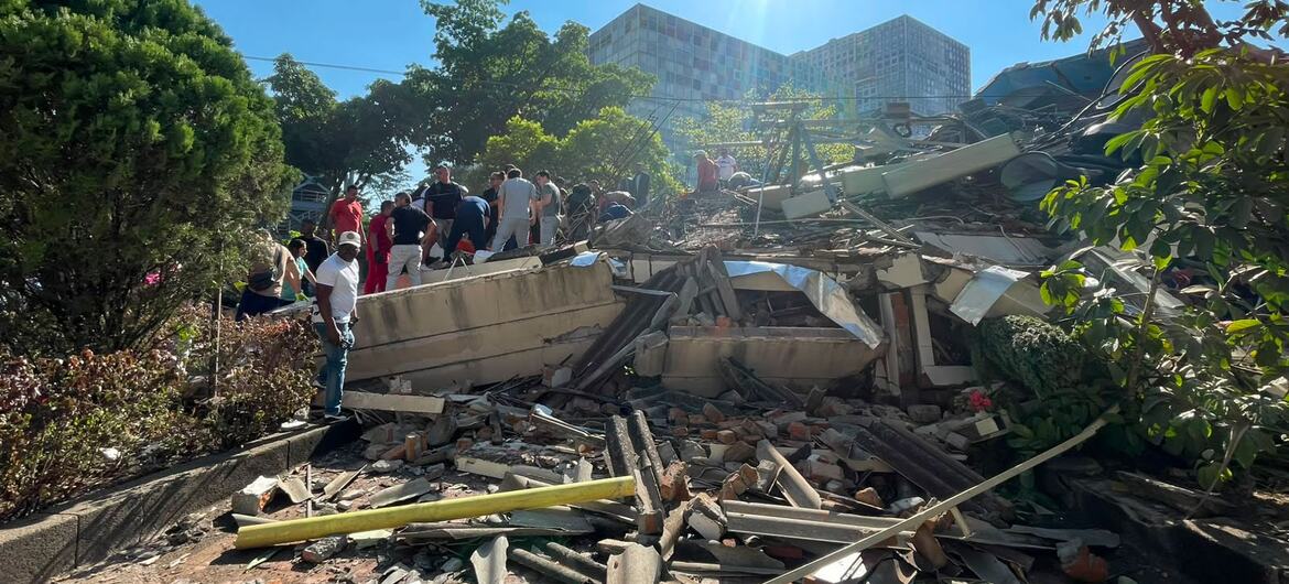 People survey the rubble of a collapsed building in Cali, Colombia after an earthquake.
