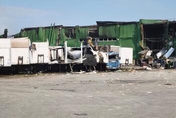 Entrepôt vert détruit et camions endommagés à Dnipro, en Ukraine.