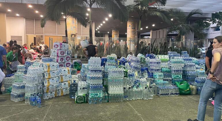 Grandes pilas de agua embotellada y suministros de ayuda humanitaria se acumulan frente a un edificio en Cali, Colombia, tras un terremoto.