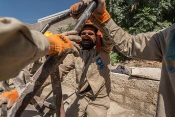 UNDP workers in Syria clearing debris from a building site.