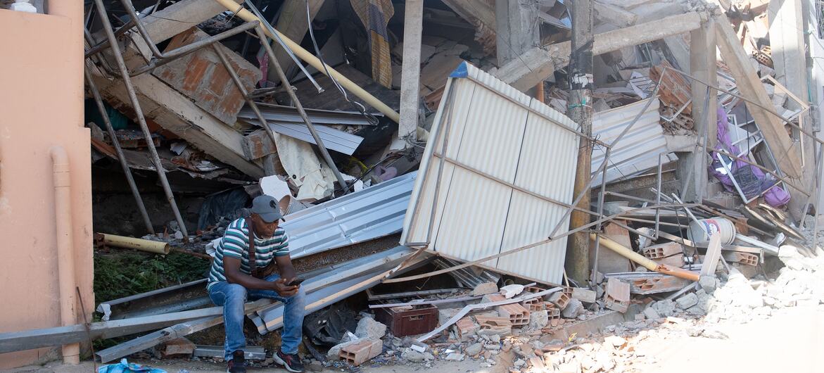 Un hombre permanece sentado entre los escombros de un edificio derrumbado tras un terremoto en Colombia.
