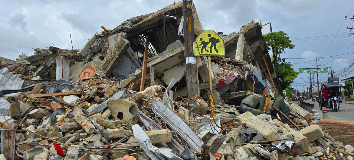 Un edificio derrumbado en Quibdó, Colombia, con escombros y restos en la calle junto a una señal amarilla de paso de peatones.