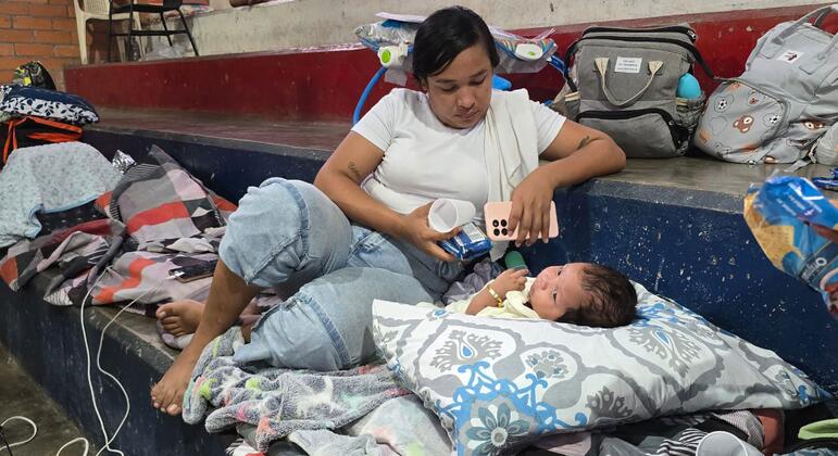 Una mujer y un bebé descansan sobre mantas y almohadas en un refugio improvisado dentro de un coliseo de boxeo en Quibdó, Colombia.