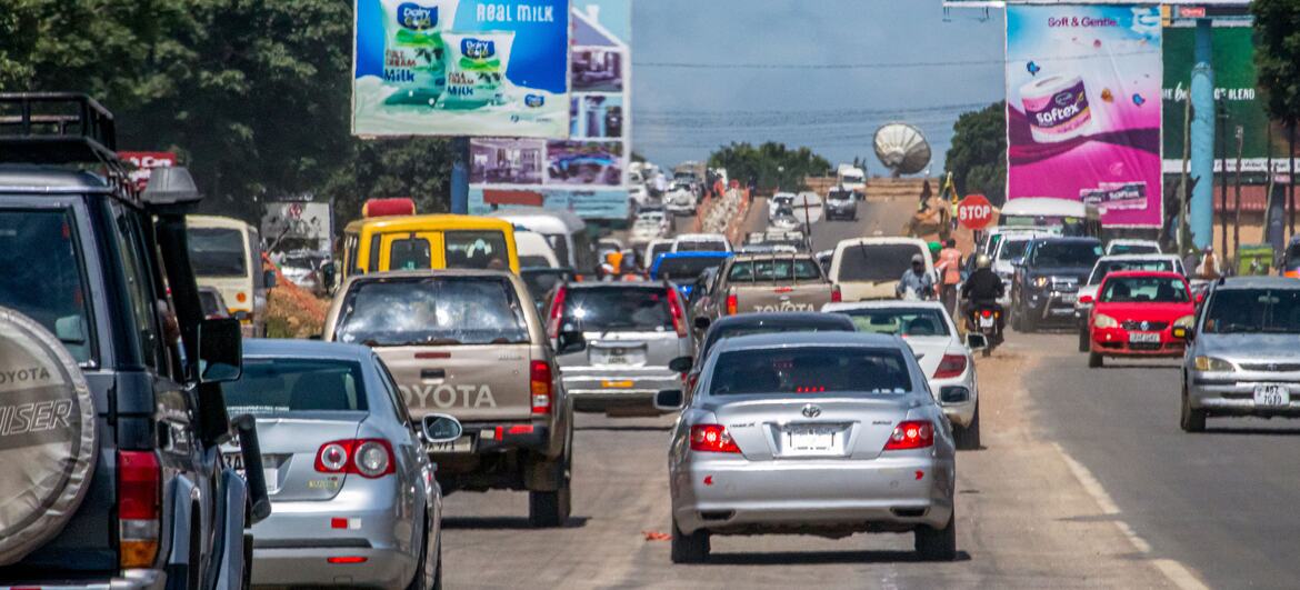 Msongamano mkubwa wa magari katika Barabara Kuu ya Mashariki huko Lusaka, Zambia, huku magari mengi na mabango makubwa yakiwa yamepangwa barabarani.