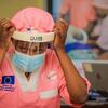 En République démocratique du Congo, une agente de santé ajuste sa visière et son masque de protection lors d'une intervention contre une épidémie d'Ebola.