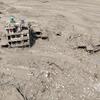 Aerial view of mud-covered buildings and debris in a settlement in Rasuwa District, central-northern Nepal, following flash floods that damaged homes and infrastructure.