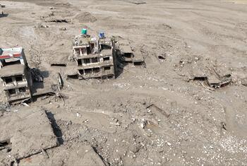 Aerial view of mud-covered buildings and debris in a settlement in Rasuwa District, central-northern Nepal, following flash floods that damaged homes and infrastructure.