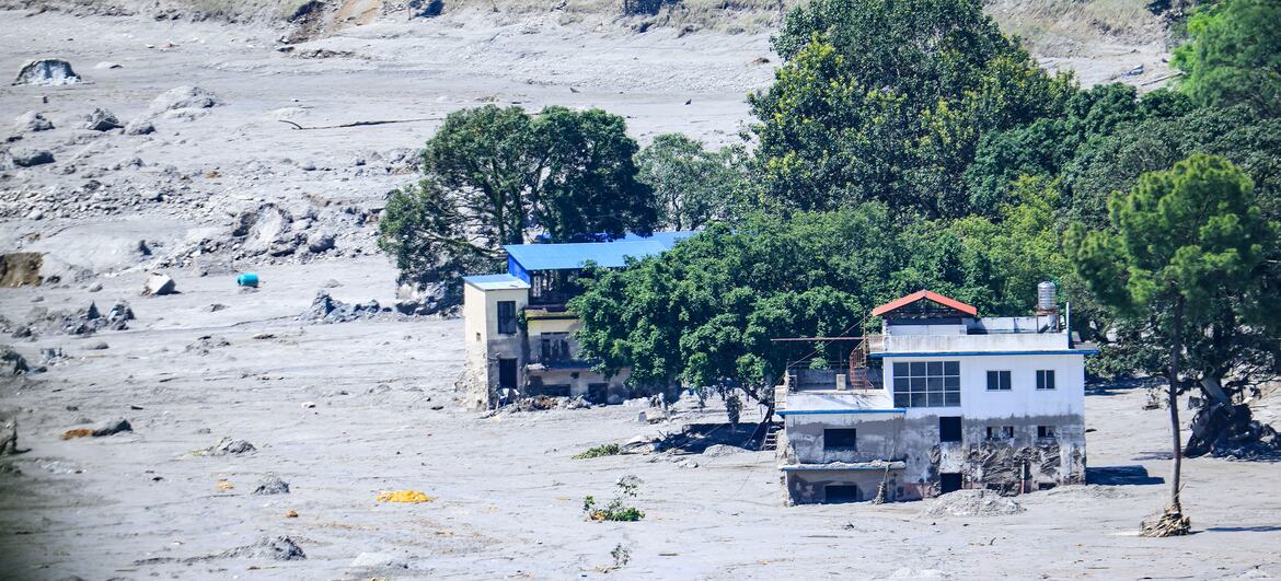 Casas cobertas de lama e um leito de rio seco em um assentamento no distrito de Nuwakot, Nepal, após enchentes repentinas devastadoras em 26 de agosto de 2026.