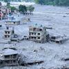 Edificios de varias plantas cubiertos de lodo y parcialmente derrumbados, junto con escombros dispersos, se observan en un asentamiento del distrito de Nuwakot, Nepal, tras las inundaciones repentinas del 26 de agosto de 2026.