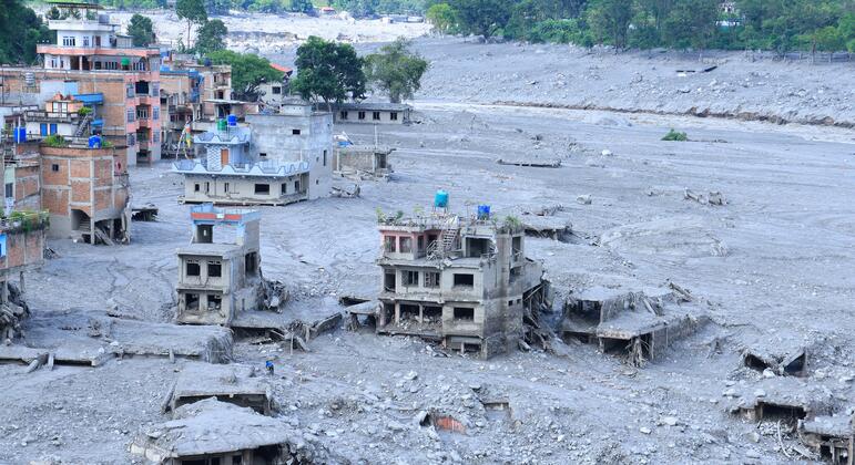 Edificios de varias plantas cubiertos de lodo y parcialmente derrumbados, junto con escombros dispersos, se observan en un asentamiento del distrito de Nuwakot, Nepal, tras las inundaciones repentinas del 26 de agosto de 2026.