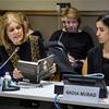 Gloria Steinem reads from the book 'The Last Girl' at a UNODC panel discussion while seated next to Nadia Murad in a conference room.