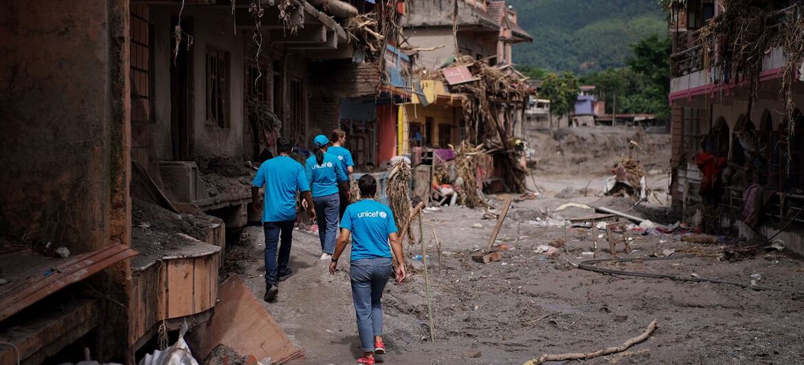 UNICEF staff walk through the devastated streets of a town in Nepal destroyed by floods.