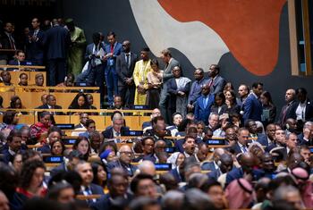 Delegates from multiple countries seated and standing in the United Nations General Assembly Hall during a formal plenary session.