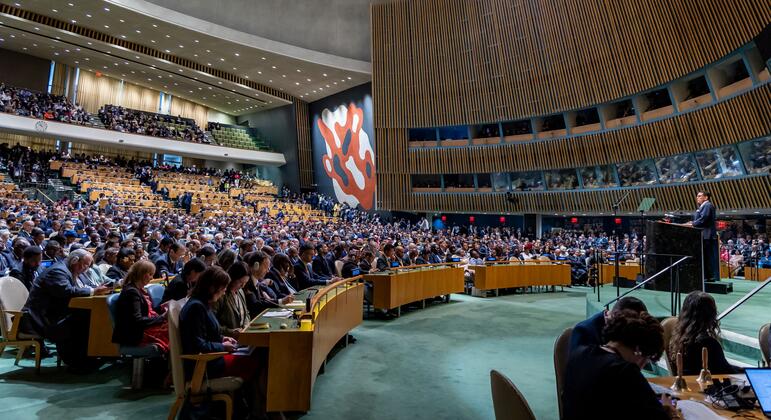 Wide-angle view of United Nations General Assembly Hall with delegates seated at desks and a speaker at the podium during the opening of the eighty-first session.