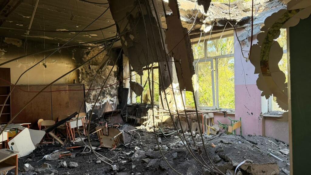 Intérieur d'une salle de classe d'une école à Odessa, en Ukraine, montrant un plafond effondré, des fils électriques apparents, des décombres et des pupitres d'enfants endommagés après une attaque survenue en septembre 2026.
