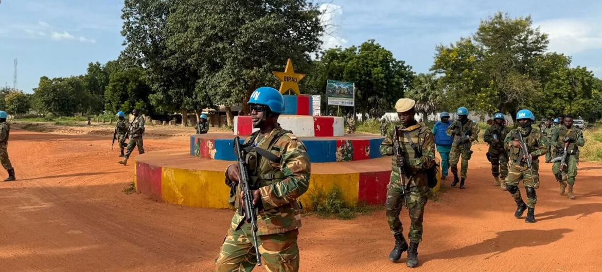MINUSCA Zambian contingent and FACA soldiers conduct an armed joint patrol in Birao, Vakaga, passing a monument with a yellow star.