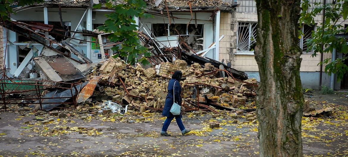 A woman walks past a destroyed home in  Borodianka, Ukraine.