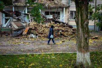 A woman walks past a destroyed home in  Borodianka, Ukraine.