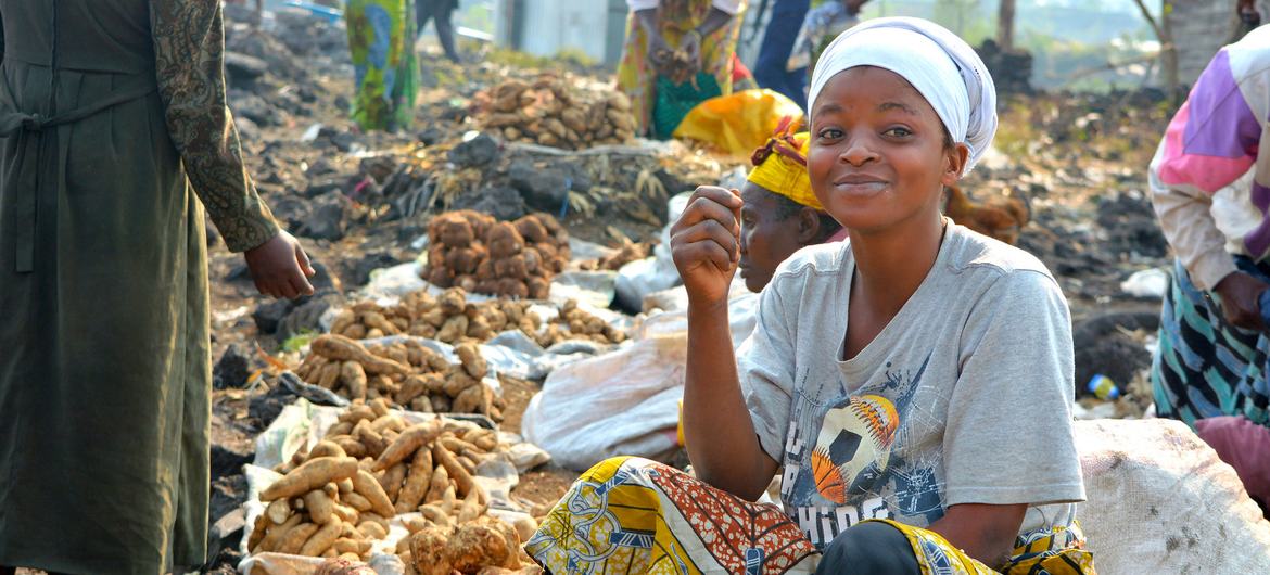 Uma mulher vende comida em um mercado na República Democrática do Congo.