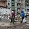 People walk past bomb-damaged building in Chernihiv in northern Ukraine.