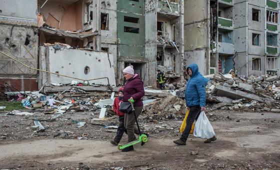 在乌克兰北部的切尔尼希夫，人们走过被炸弹摧毁的建筑。