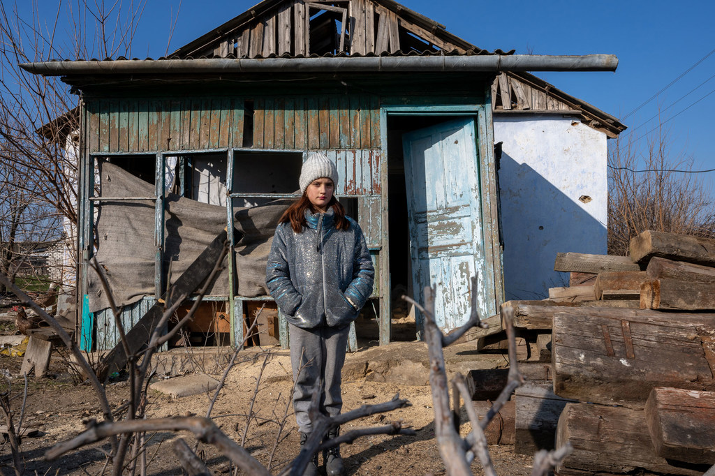 Une fille devant sa maison détruite dans le village de Kobzartsi, dans la région de Mykolaïv, en Ukraine.