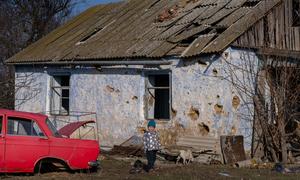 Roma, 4, stands in front of his destroyed home in Kobzartsi, Mykolaiv region