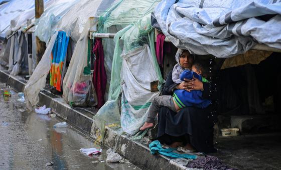 Una mujer y su hijo se resguardan de la lluvia en la ciudad de Rafah, en el sur de la Franja de Gaza.