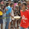 Crianças no Haiti fazem fila para receber uma refeição quente e água distribuída pelo PMA em Porto Príncipe