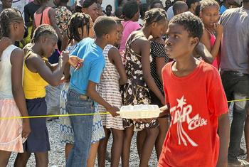 Niños haitianos hacen cola para recibir una comida caliente y agua distribuidas por el PMA en Puerto Príncipe.