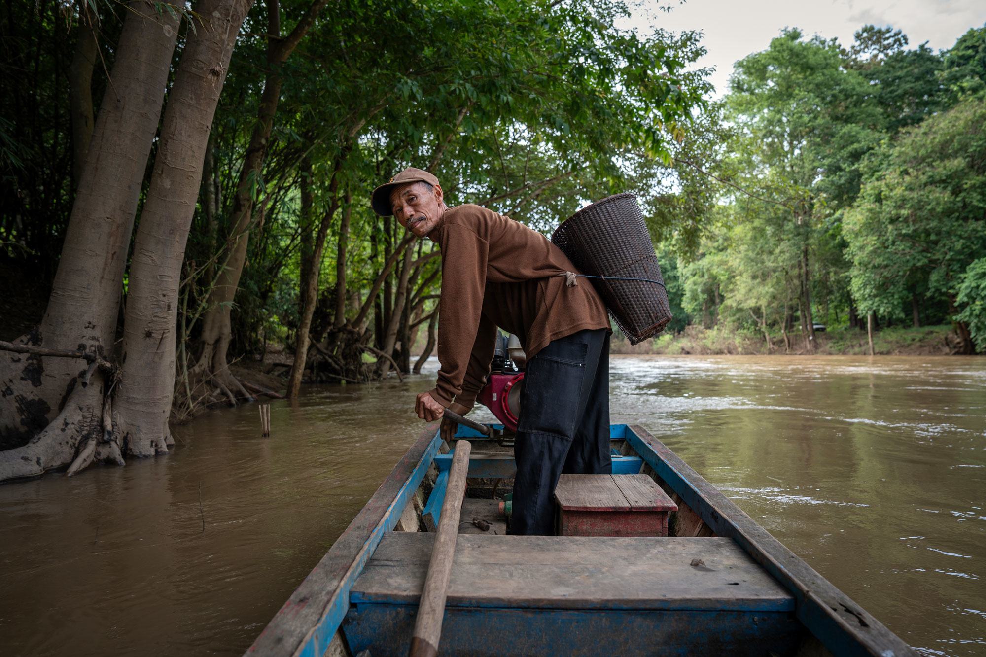 Un pêcheur se fraye un chemin à travers une forêt du nord de la Thaïlande.