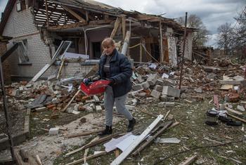 امرأة تجمع ممتلكاتها من منزلها الذي تعرض للقصف في قرية نوفوسيليفكا، بالقرب من تشيرنيهيف، بأوكرانيا.