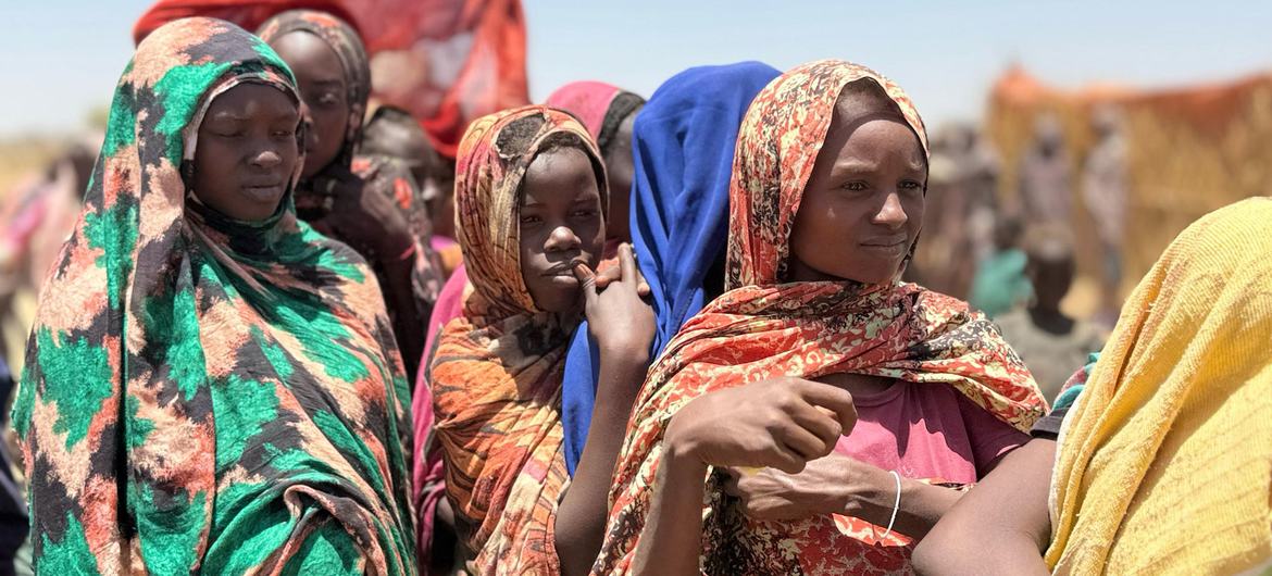 Unge kvinder står i kø for at modtage humanitær hjælp i en lejr for fordrevne i Sudan.
